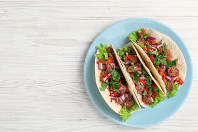 Photo of Delicious tacos with meat and vegetables on wooden table, top view. Space for text