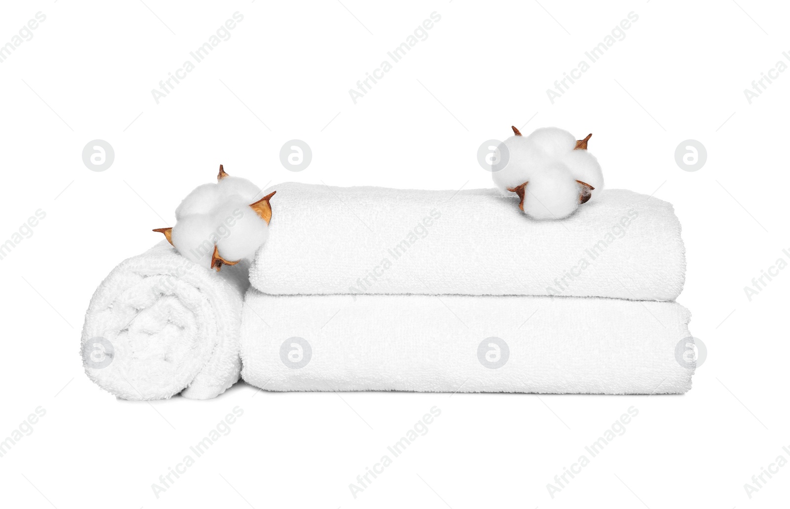 Photo of Soft terry towels with cotton flowers on white background
