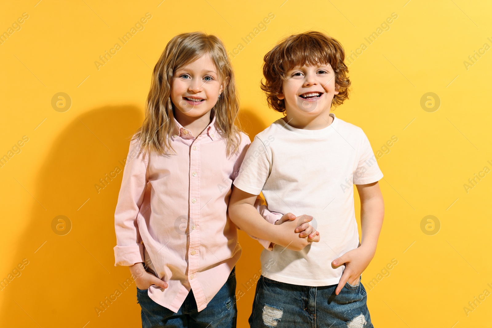 Photo of Fashion concept. Stylish children posing on yellow background