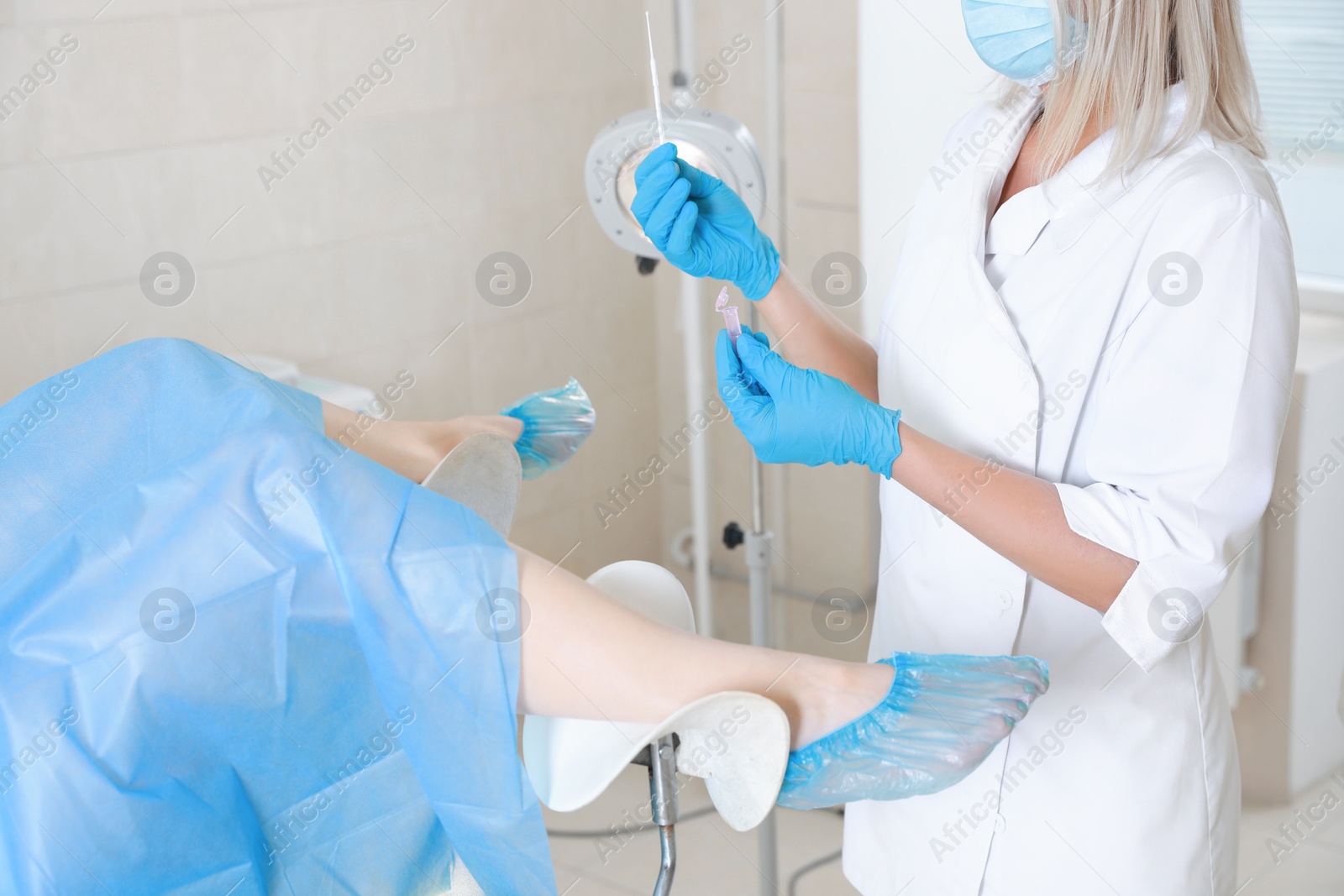 Photo of Woman having appointment with doctor. Gynecologist examining patient on chair in clinic, closeup