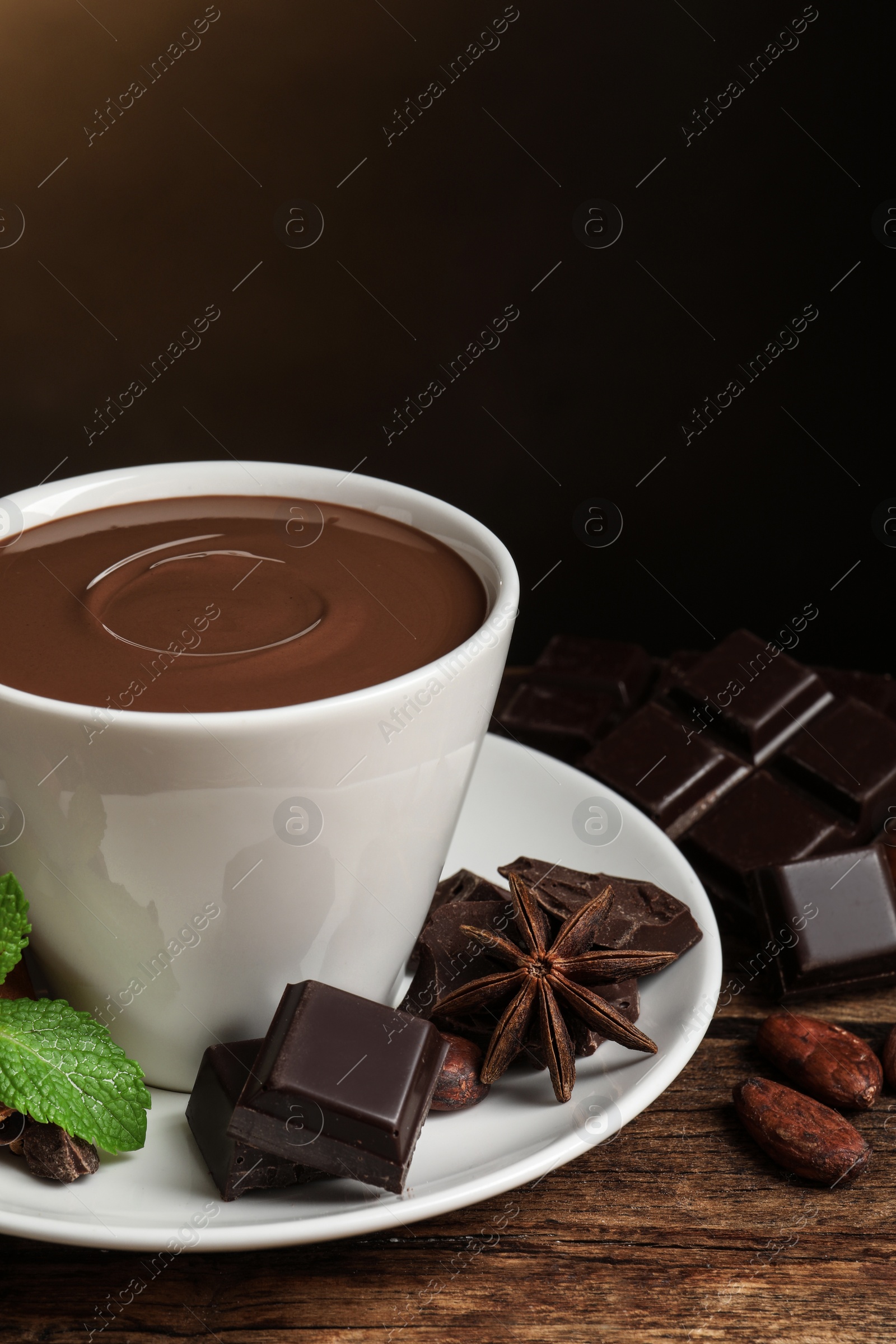 Photo of Yummy hot chocolate in cup on wooden table, closeup