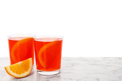 Photo of Aperol spritz cocktail and orange slices in glasses on marble table against white background, space for text