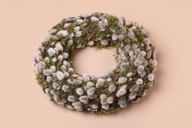 Photo of Wreath made of beautiful willow flowers on beige background