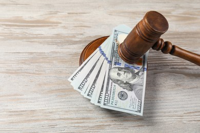 Photo of Judge's gavel and money on wooden table. Space for text