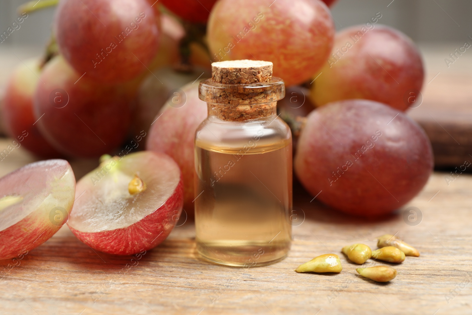 Photo of Natural grape seed oil on wooden table. Organic cosmetic