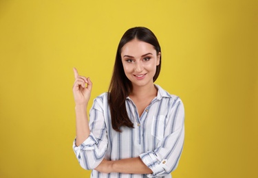 Photo of Beautiful young woman in casual outfit on yellow background