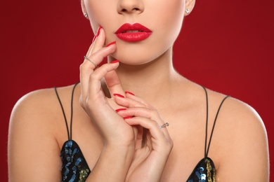 Beautiful young woman with bright manicure on color background, closeup. Nail polish trends