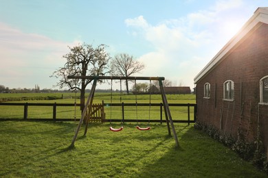 Photo of Outdoor swings near building on spring day