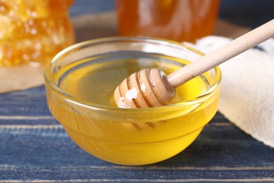 Photo of Tasty fresh honey on blue wooden table