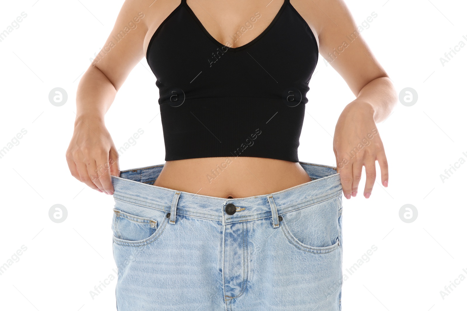 Photo of Slim woman in oversized jeans on white background, closeup. Weight loss