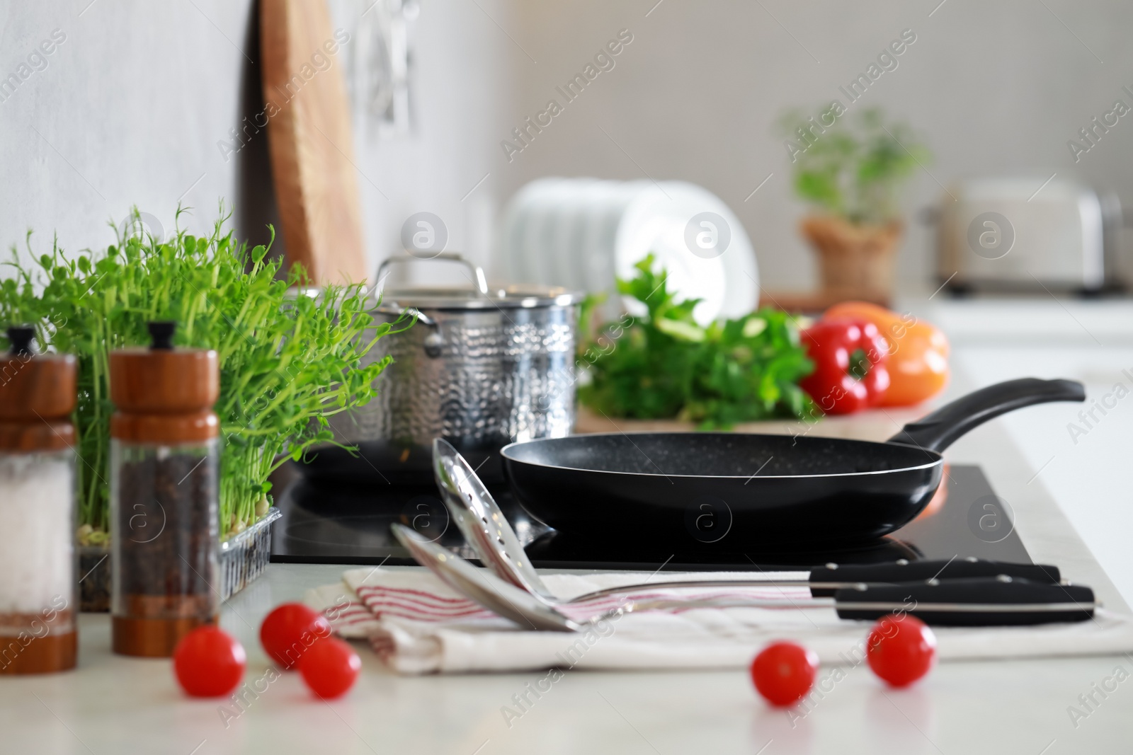 Photo of Countertop with different cooking utensils and vegetables in kitchen