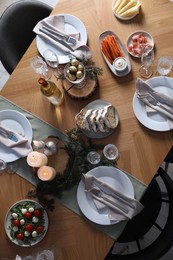 Photo of Christmas table setting with festive decor and dishware, top view