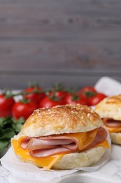 Photo of Delicious bagel with ham and cheese on table. Space for text
