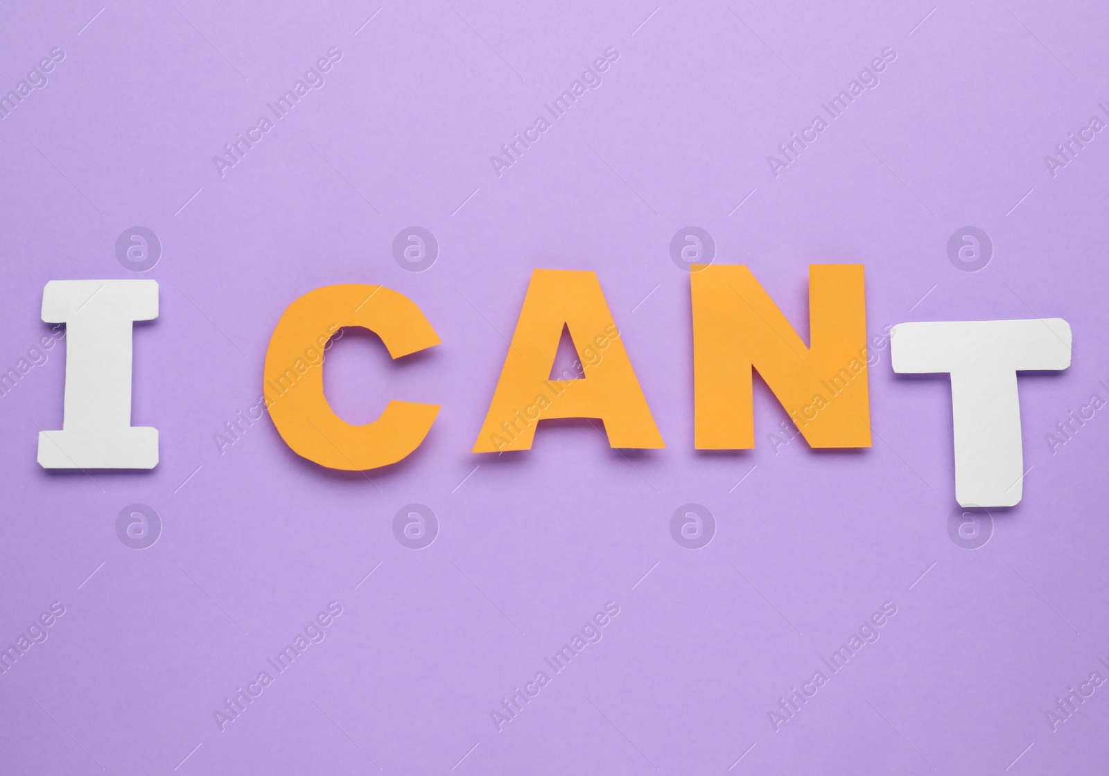 Photo of Motivation concept. Changing phrase from I Can't into I Can by removing paper letter T on violet background, top view
