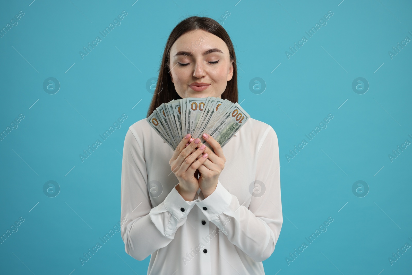 Photo of Smiling woman with dollar banknotes on light blue background