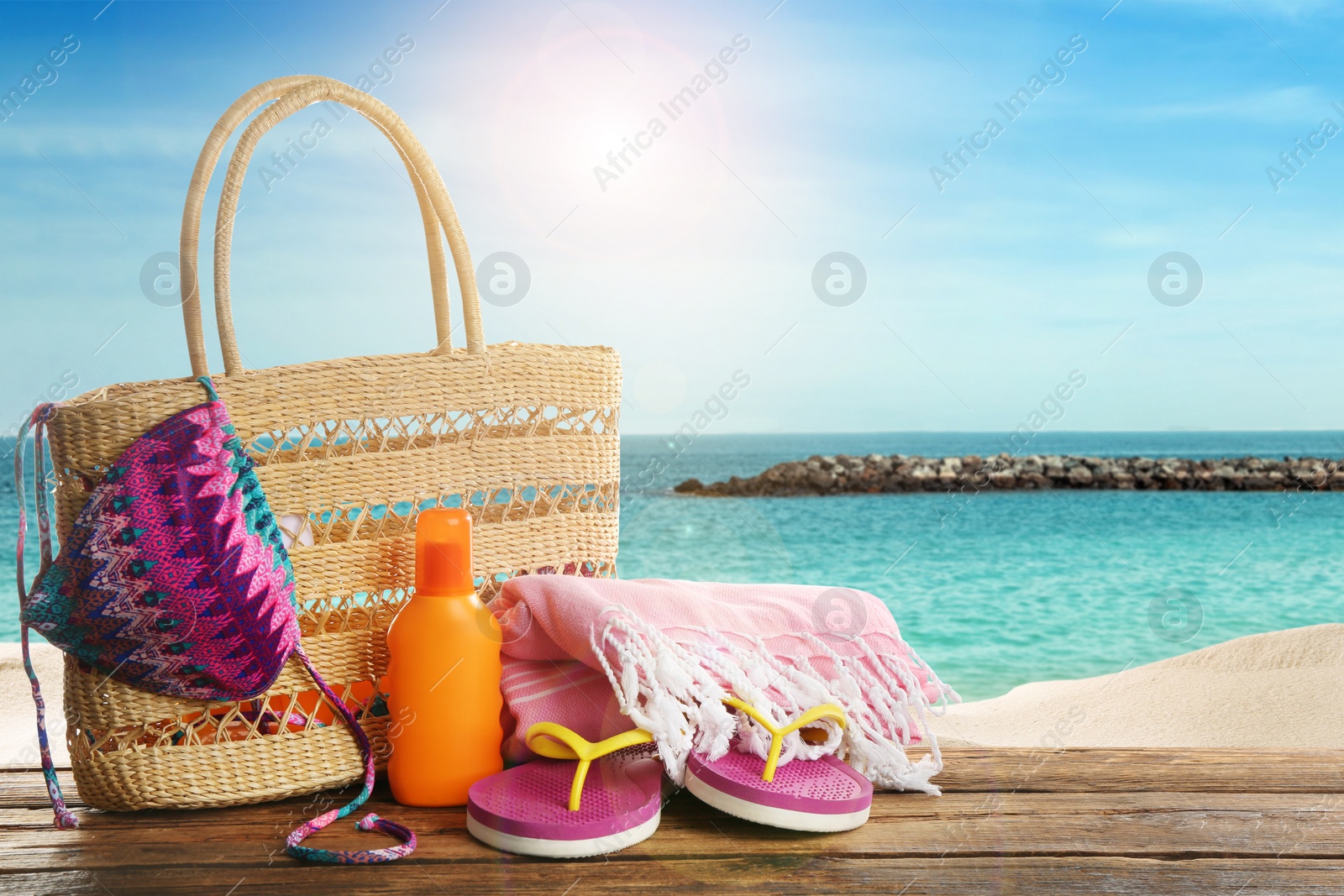 Image of Beach accessories on wooden surface near ocean 