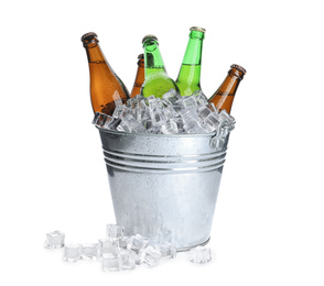 Photo of Metal bucket with bottles of beer and ice cubes isolated on white