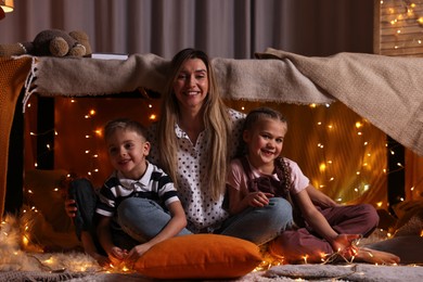 Mother and her children in play tent at home