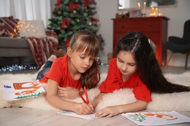 Photo of Little children writing letter to Santa at home. Christmas celebration