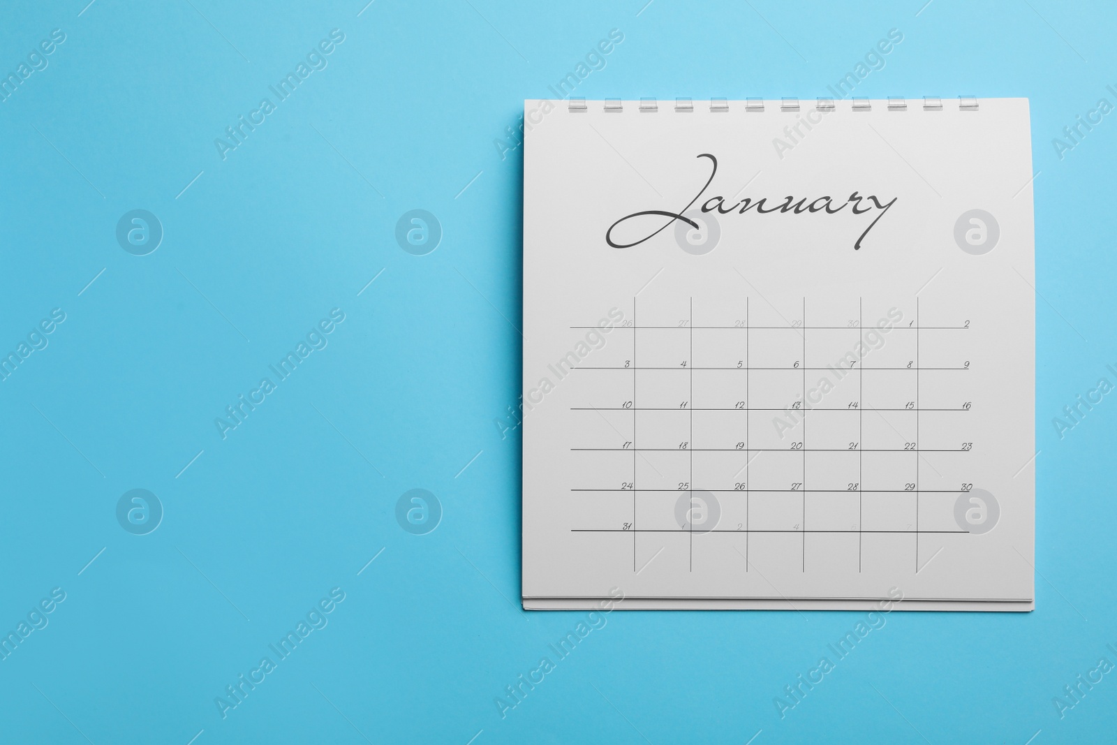 Photo of January calendar on light blue background, top view. Space for text