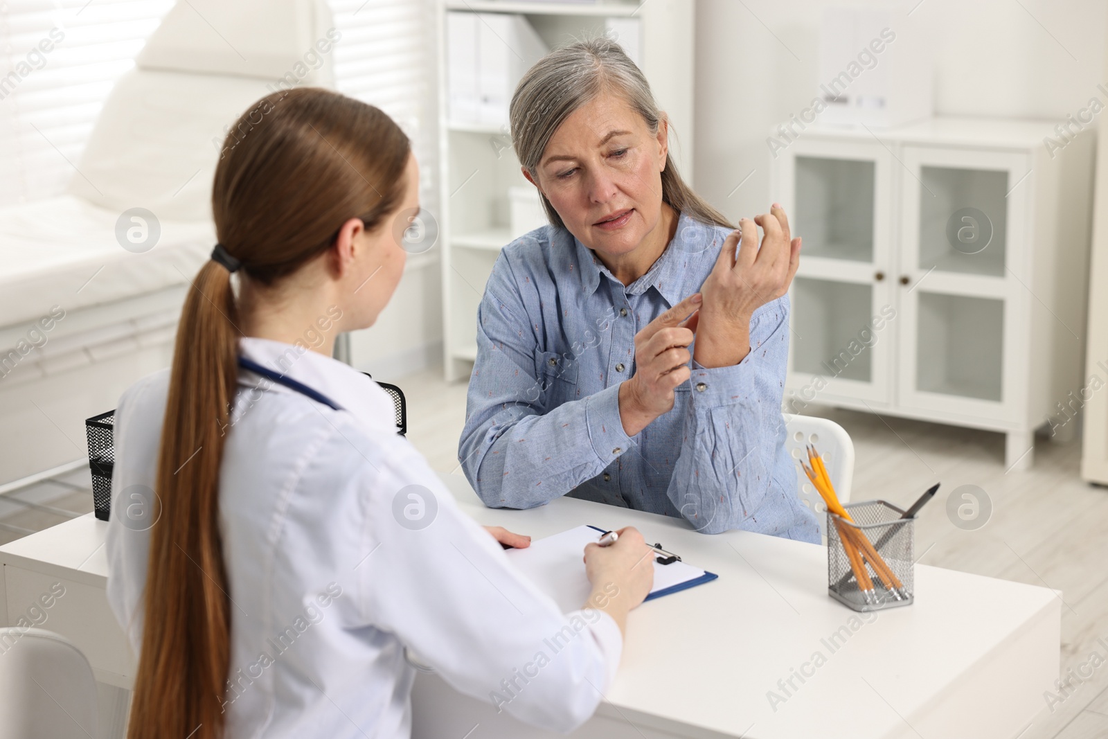 Photo of Arthritis symptoms. Doctor examining patient's wrist in hospital