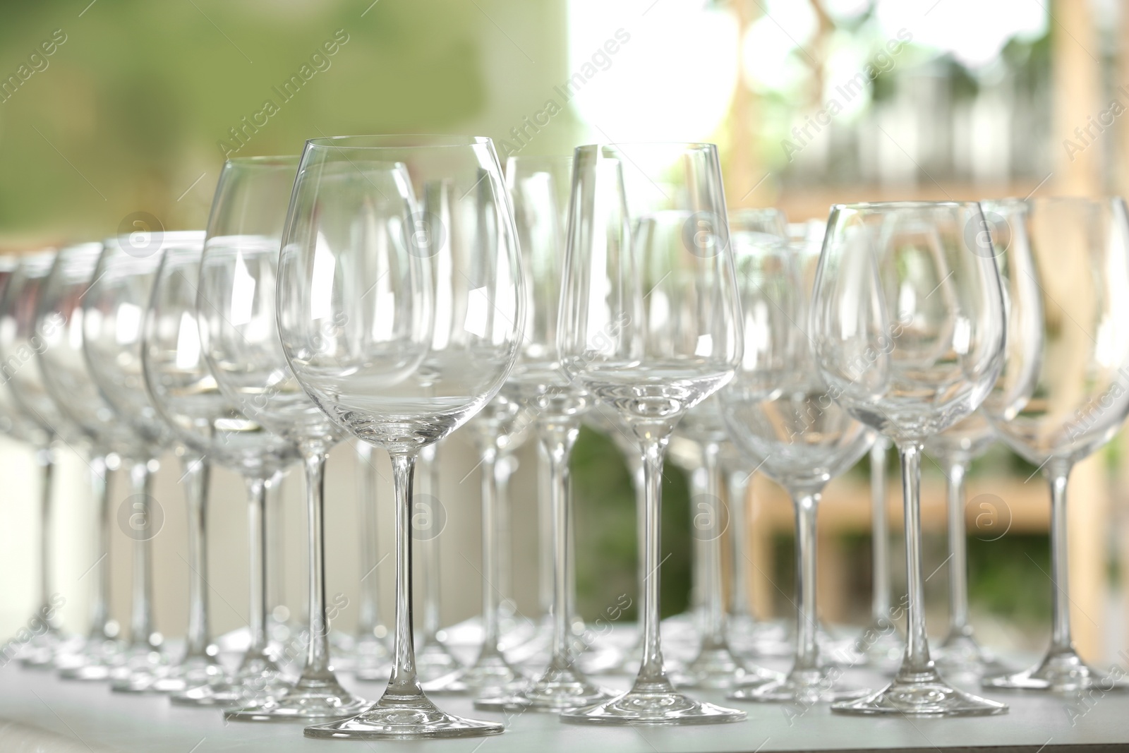 Photo of Empty glasses on table against blurred background