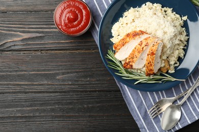 Delicious chicken risotto served on black wooden table, flat lay. Space for text