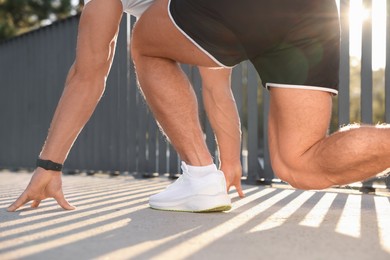 Photo of Runner on starting position outdoors on sunny day, closeup