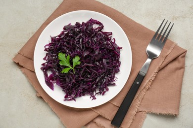 Photo of Tasty red cabbage sauerkraut with parsley served on beige table, top view