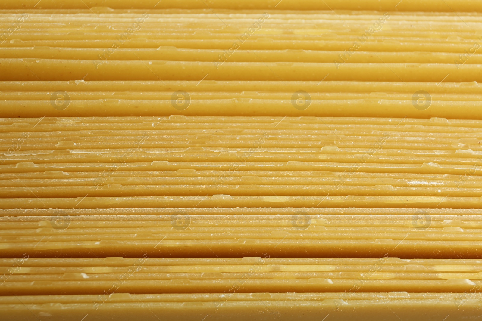 Photo of Pile of dry lasagna sheets as background, closeup