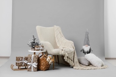 Photo of Stylish photo zone with armchair and Christmas decor in professional studio