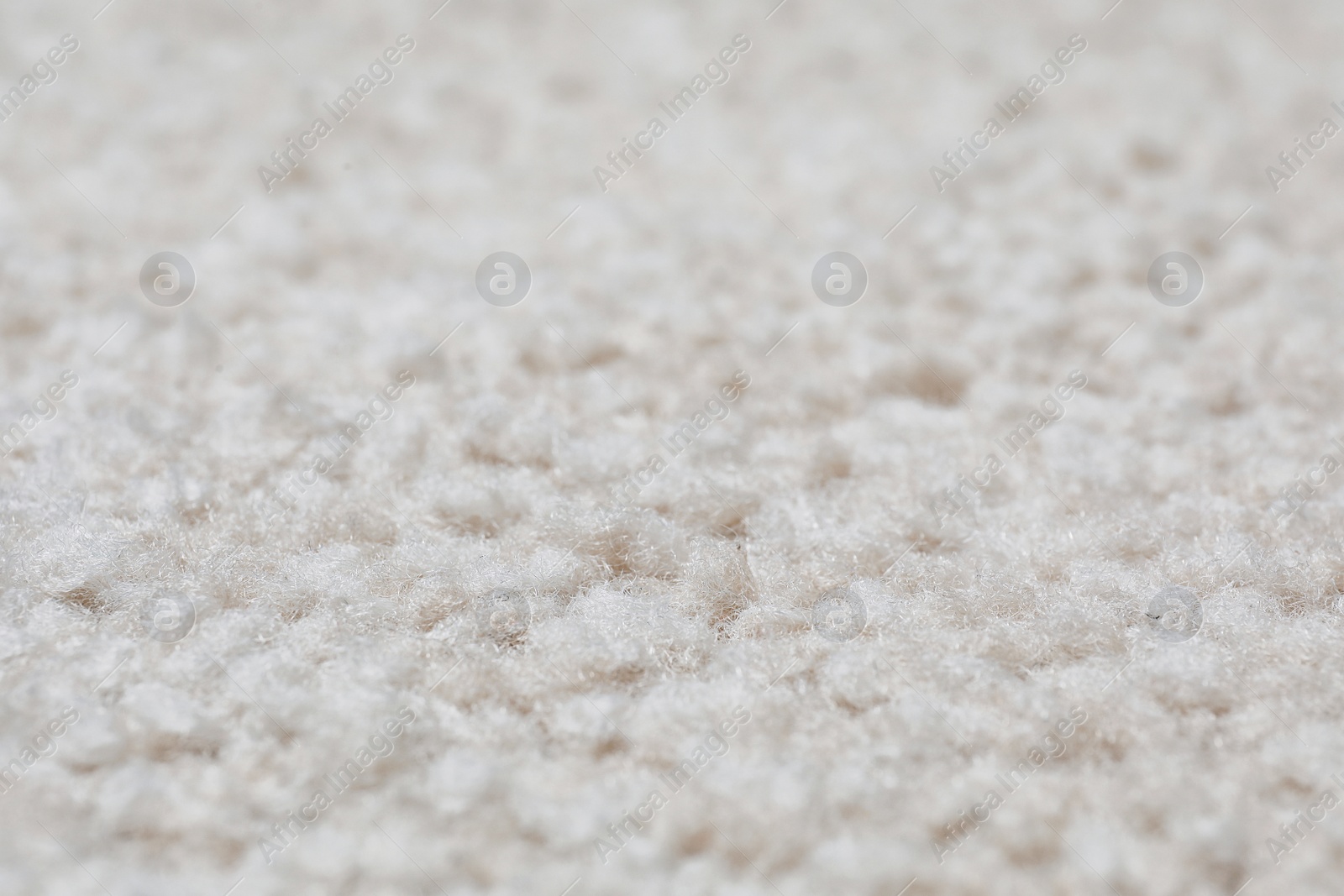 Photo of Fuzzy beige carpet texture as background, closeup