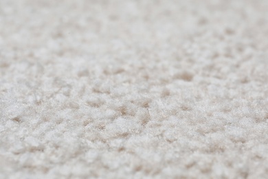 Photo of Fuzzy beige carpet texture as background, closeup