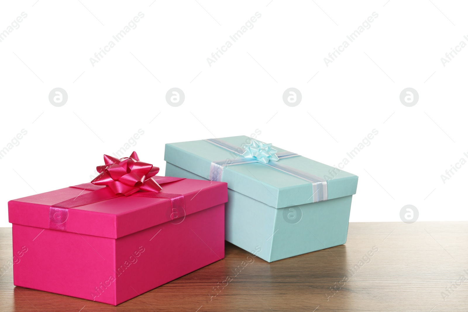 Photo of Pink and light blue gift boxes on wooden table against white background