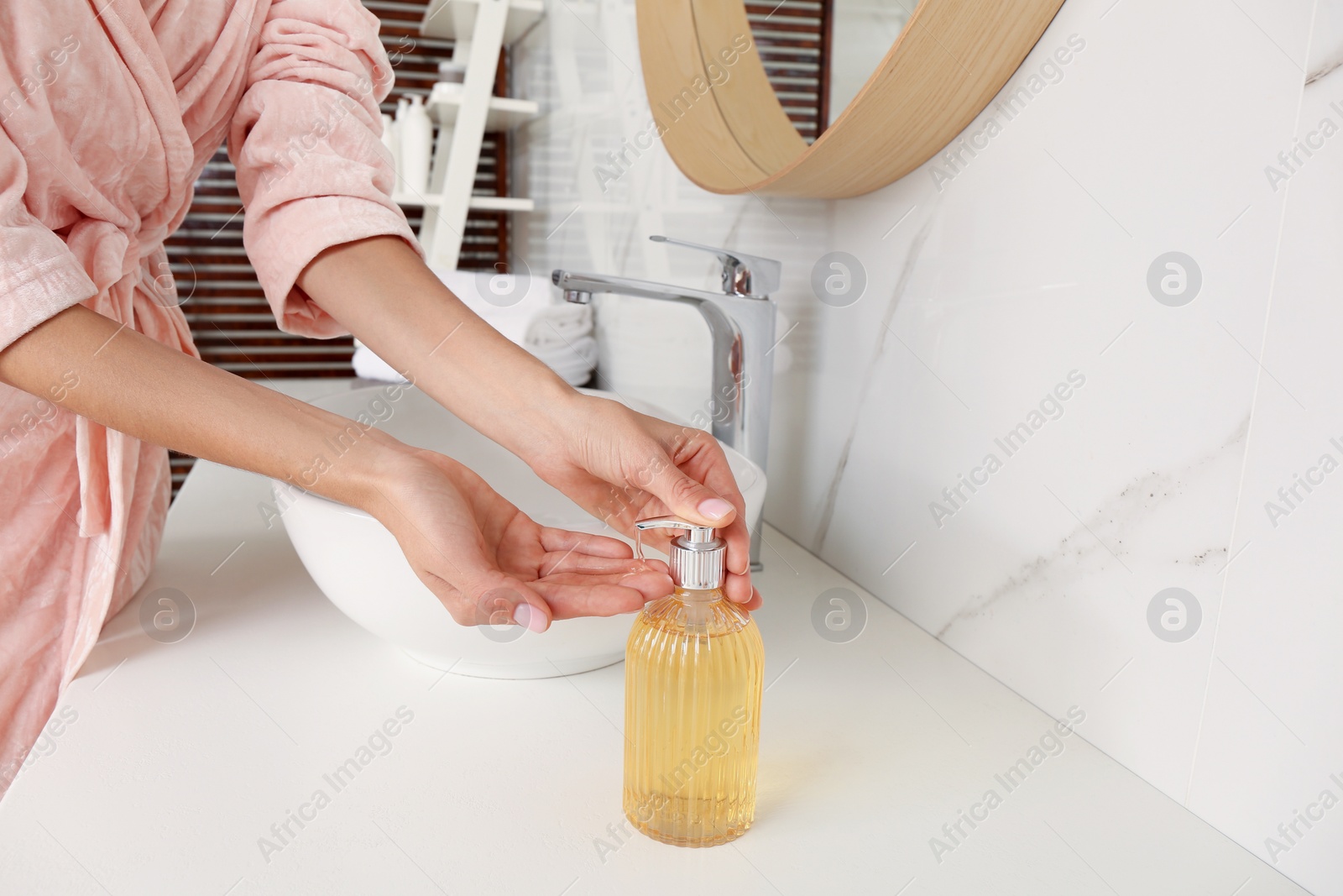 Photo of Woman using liquid soap dispenser at counter, closeup