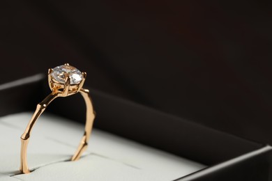 Beautiful engagement ring in box, closeup. Space for text