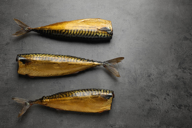 Photo of Tasty golden smoked fish on grey table, flat lay