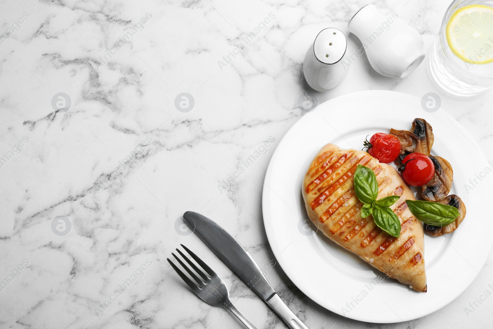 Photo of Tasty grilled chicken fillet served on white marble table, flat lay. Space for text