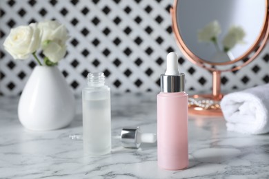 Bottles of serum on white marble table. Cosmetic products