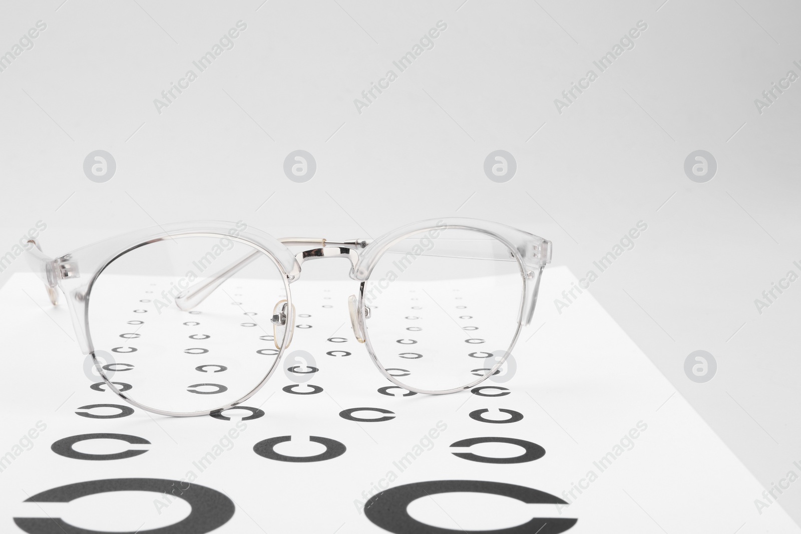 Photo of Glasses and vision test chart isolated on white