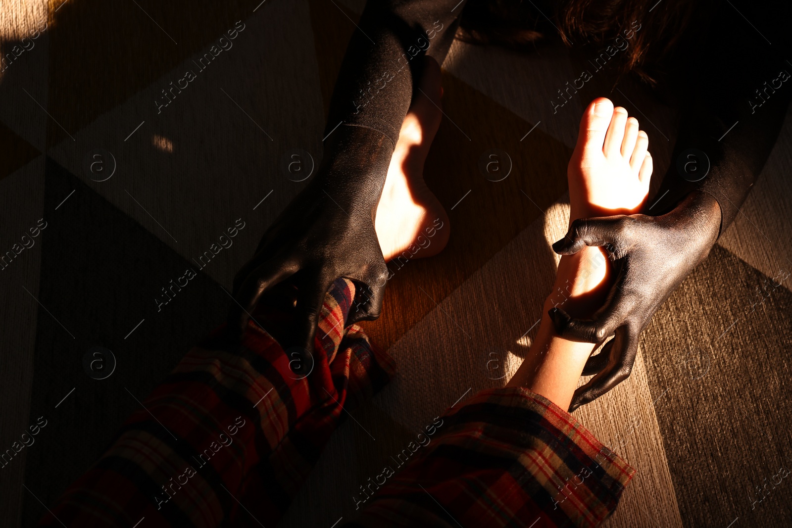 Photo of Scary monster under bed grabbing little girl by legs, closeup