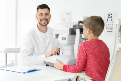 Ophthalmologist examining little boy in clinic