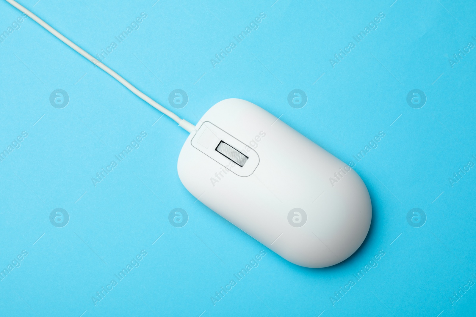 Photo of Wired computer mouse on light blue background, top view