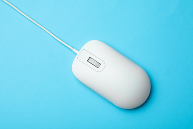 Photo of Wired computer mouse on light blue background, top view