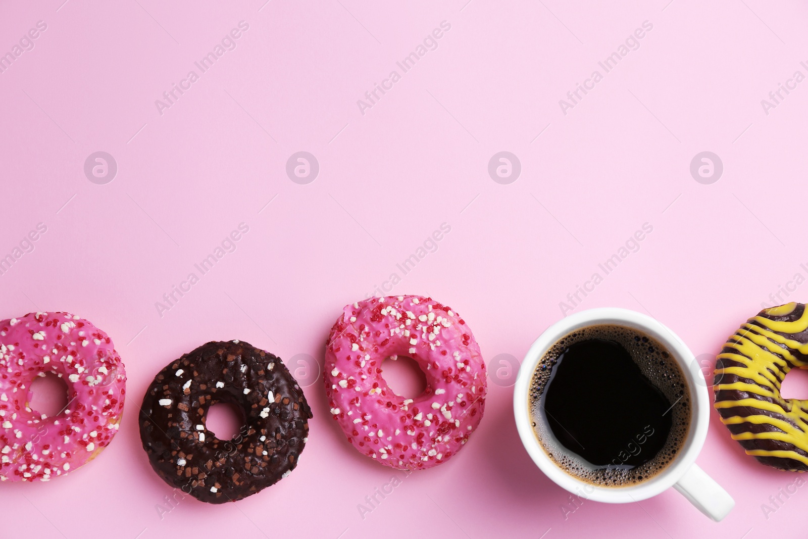 Photo of Tasty donuts and cup of coffee on pink background, flat lay. Space for text