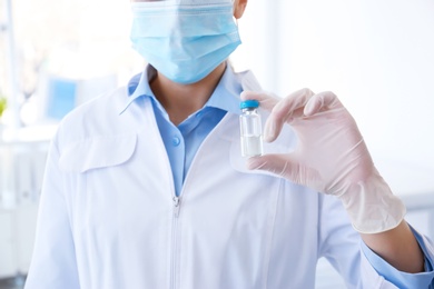 Photo of Female doctor with vial in hospital. Vaccination day