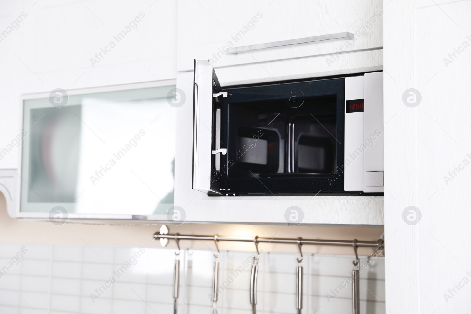 Photo of Open modern microwave oven built in kitchen furniture