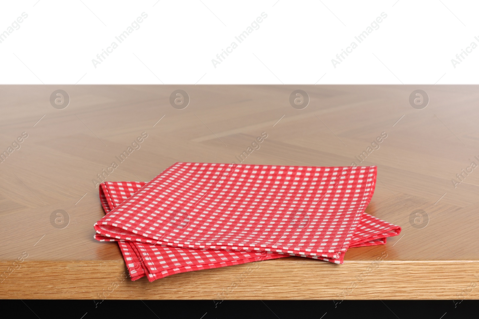 Photo of Checkered tablecloth on wooden table against white background