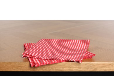Checkered tablecloth on wooden table against white background