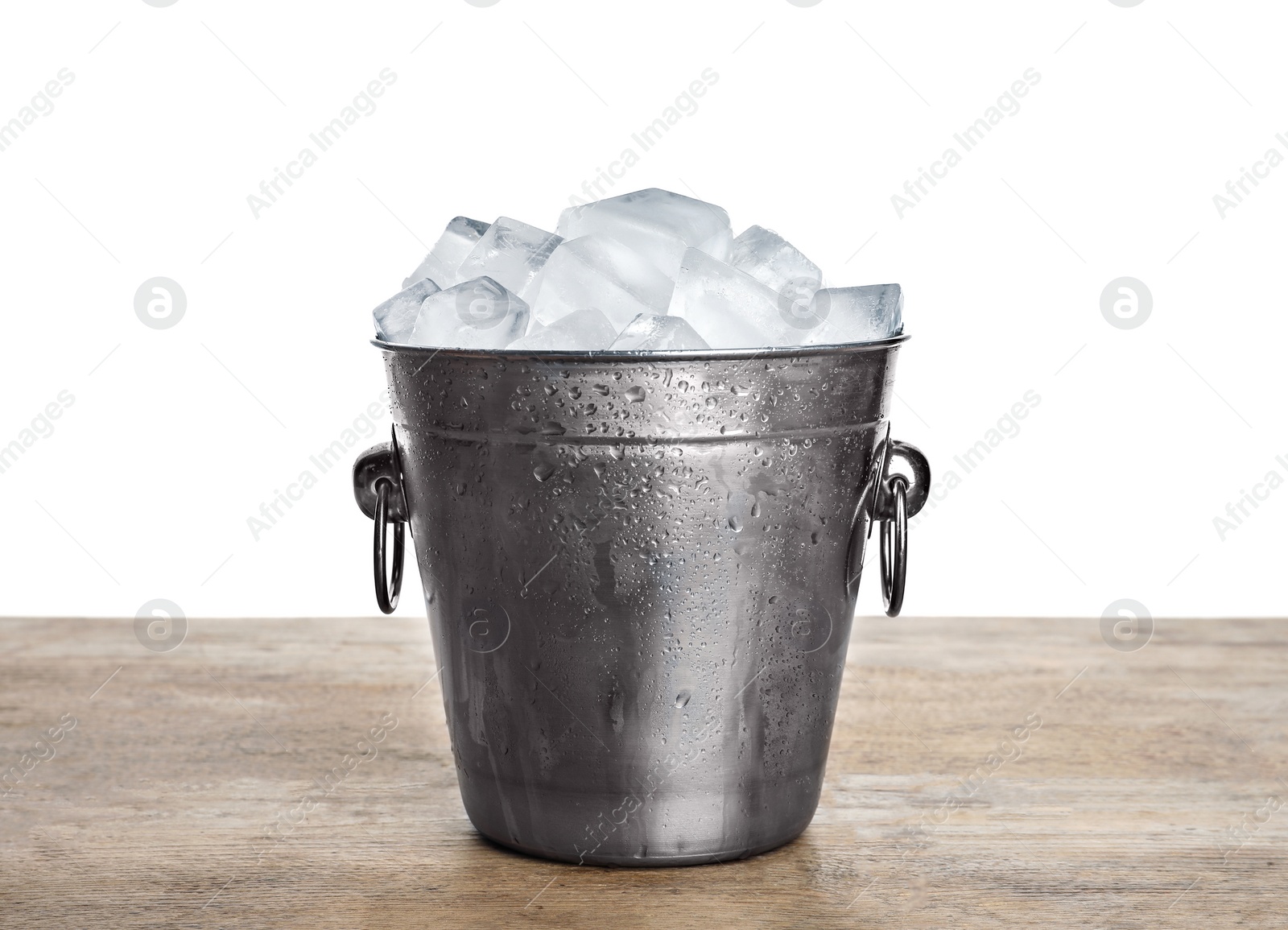 Photo of Metal bucket with ice cubes on wooden table against white background